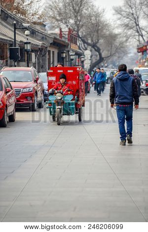 Beijing, China - March 12, 2016: People Are Driving Through The Streets With Bicycles, Scooters And 