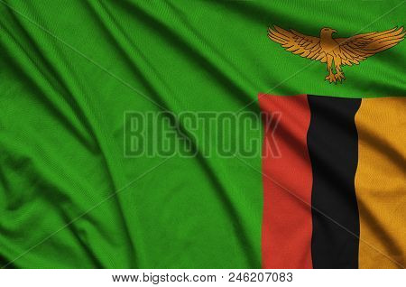 Zambia Flag  Is Depicted On A Sports Cloth Fabric With Many Folds. Sport Team Waving Banner