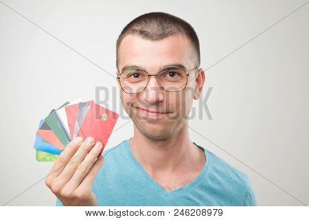 Close Up Portrait Of Young Man In Glasses Holding A Lot Of Gredit Cards. Concept Of Non Cash Finance
