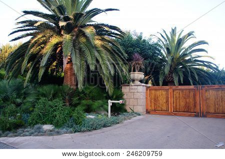 House With Green Lawn Manicured Frontyard Garden In Suburban Residential Neighborhood On A Sunny Day