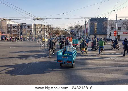 Beijing, China - March 10, 2016: People Are Driving Through The Streets With Bicycles, Scooters And 