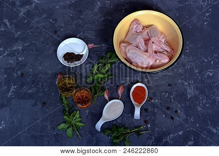 Ingredients For Marinating Chicken Wings On A Dark Gray Concrete Background. Raw Chicken Wings, Oliv