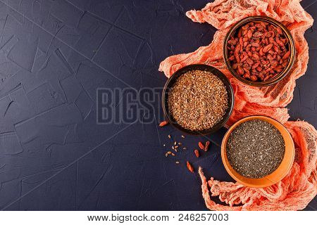 Super Foods - Chia Seeds, Flax Seeds And Goji Berries In Three Ceramic Bowls