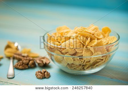 Tasty Cornflakes With Walnut In Glass Bowl On Blue Background. Corn Flakes