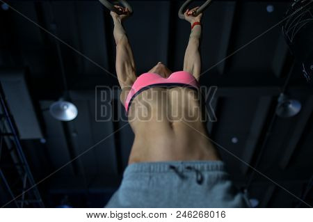 Young Woman Doing A Pullup Ongymnastic Rings, In The Gym.