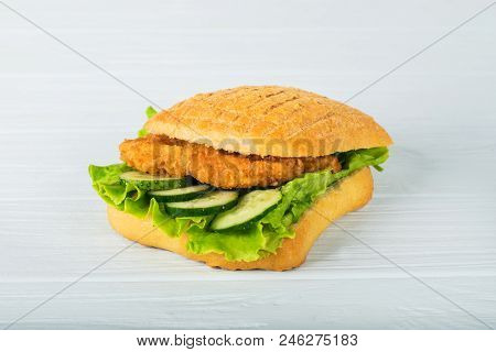 Pressed And Toasted Double Panini With Ham And Cheese Served On Sandwich Paper On A Wooden Table