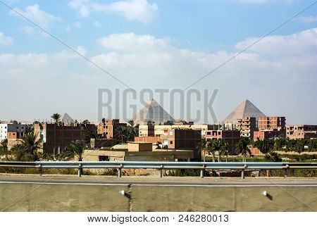 View Of The Pyramids Of Keops, Kefren And Menkaure From The Ring Road Of Cairo. Ahead Half-built Hom