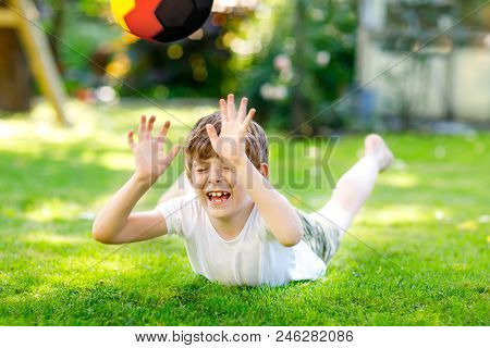 Happy Active Kid Boy Playing Soccer With Ball In German Flag Colors. Healthy Child Having Fun With F