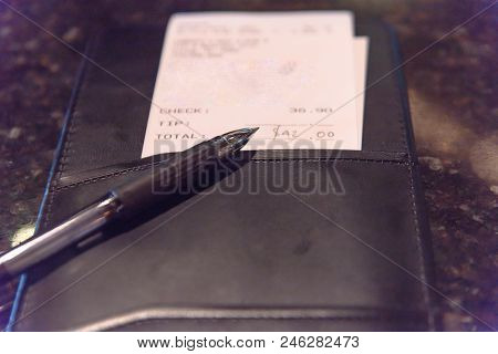 Close-up Leather Holder With Restaurant Bill Check And Pen