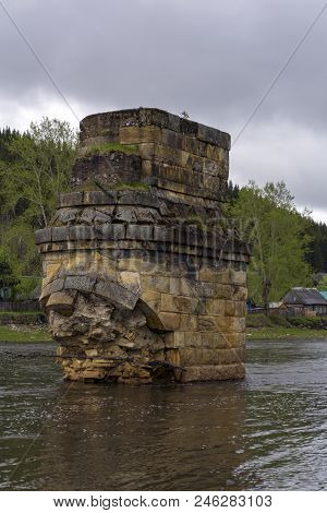 Support Of An Ancient River Bridge Destroyed By An Ice Break Across The River In The Village