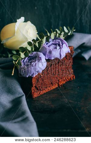 Piece Of Birthday Chocolate Cake With Purple Cream Roses