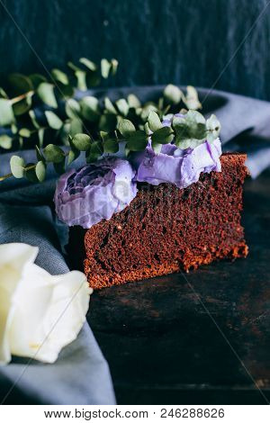Piece Of Birthday Chocolate Cake With Purple Cream Roses