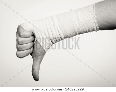 Bad News And Information. Medicine Aspects. Male Hand With Bandage Showing Thumb Down Sign Symbol.