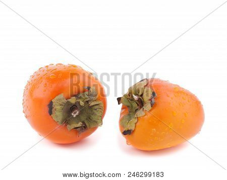 Two Ripe Persimmons Of Bright Orange Colour Are Situated On The White Background.