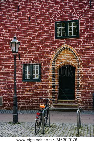 Traditional Medieval German Brick House In Luneburg, Germany. Fragment Sticking Out Of The Facade. B