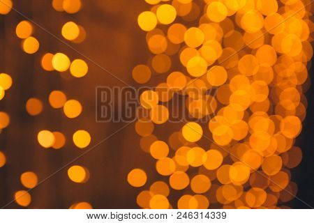 Many Blurred Small Electric Bulbs On A Wall. Yellow Blurred Lights. Wall Of Christmas Lights