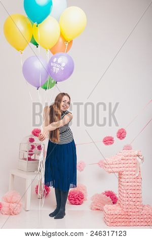 The Blonde Woman With The Colored Balls On A White Background. Studio Portrait Of An Attractive Girl
