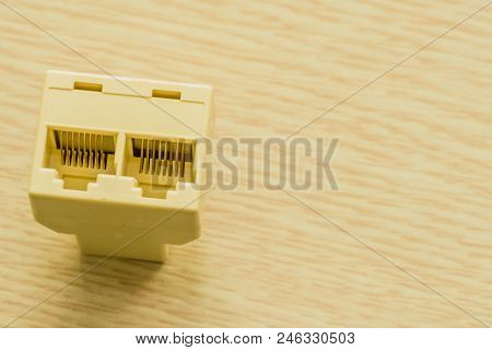 Closeup Of Plastic Ethernet Splicer That Allows Two Ethernet Cable To Be Plugged In From A Single Ro