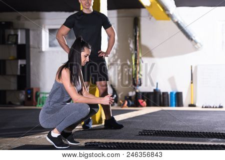 young fit sports couple working out in functional training gym doing  battle ropes cross fitness exercise