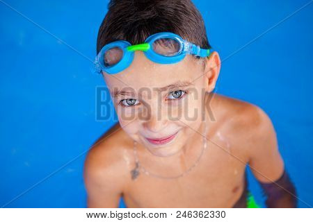 Smiling Baby Boy With Swimming Glasses In Swimming Pool.