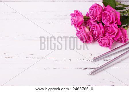 Bunch Of Pink  Roses  Flowers  And Two Silwer Candles On White Wooden Background. Floral Still Life.
