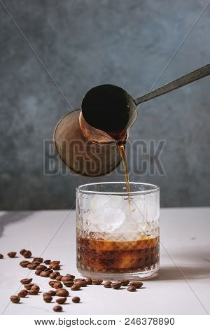 Iced Coffee Cocktail Or Frappe With Ice Cubes And Cream Served In Glass With Pouring Coffee From Vin