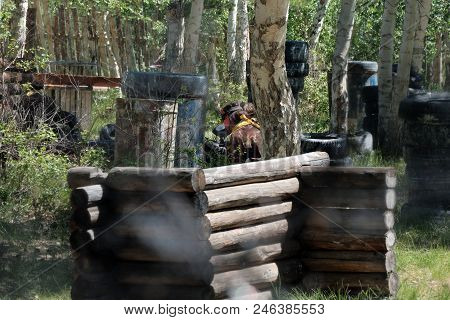 Game In A Paintball. Players Playing In The Forest.
