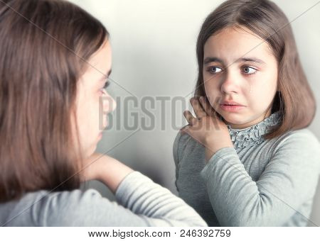 The Girl Cries, Looking At Her Reflection In The Mirror.