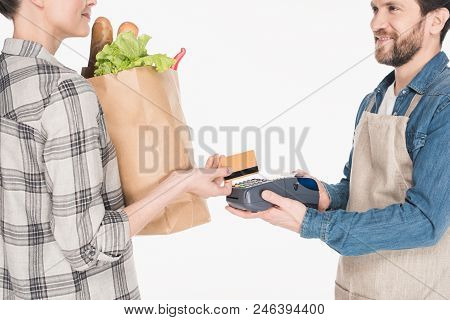 Partial View Of Woman With Paper Package With Food Giving Credit Card To Shop Assistant With Cardkey