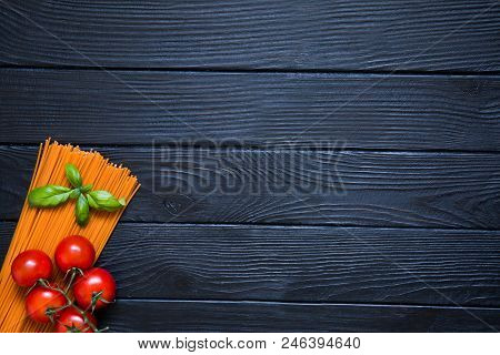 Organic Tomato Spaghetti With Fresh Cherries And Basil Leaf On Black Wooden Background. Italian Cuis