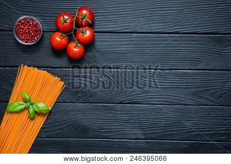 Organic Spaghetti With Fresh Cherries, Red Pepper In Little Glass Bowl And Basil Leaf On Black Woode