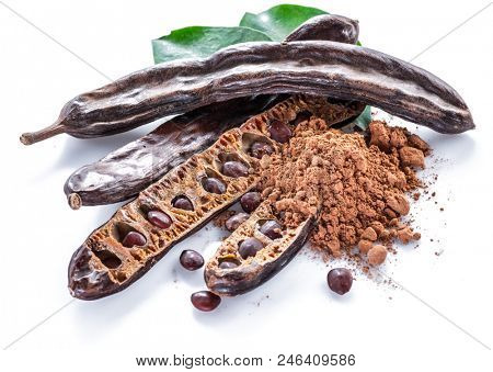 Carob pods and carob powder on the white background.