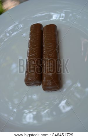 On White Plate Of Glass Are Two Bars, Chocolate Bar, Shortbread Cookies With Caramel, Covered With L