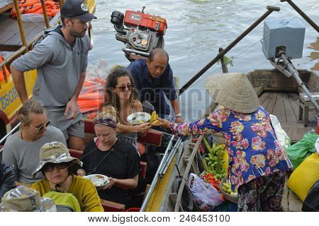 Phong Dien, Vietnam - December 31st 2017. A Tourist On A Boat Tour Considers Buying Bananas From A V