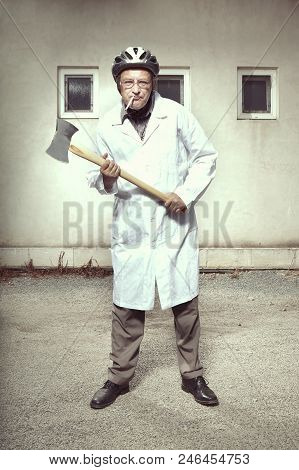Older Paramedic Freak Man In Medical Coat And Protective Helmet Became Angry With Double Axe