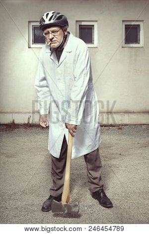 Older Paramedic Freak Man In Medical Coat And Protective Helmet Became Angry With Double Axe