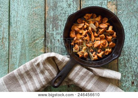 Chanterelle Mushrooms Fried In Cast Iron Pan With Linen Cloth On Blue Background. Healthy Vegetarian