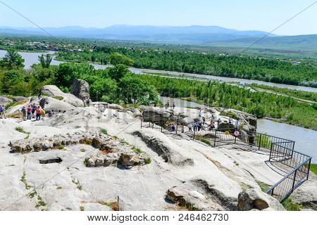 UPLISTSIKHE - MAY 5: Tourists enjoy the sunny weather and walk around the ancient rock city on 5 May 2018 in Uplistsikhe (Upliscyche), Georgia