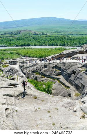 UPLISTSIKHE - MAY 5: Tourists enjoy the sunny weather and walk around the ancient rock city on 5 May 2018 in Uplistsikhe (Upliscyche), Georgia