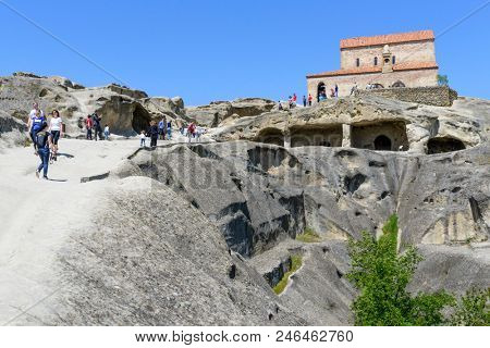 UPLISTSIKHE - MAY 5: Tourists enjoy the sunny weather and walk around the ancient rock city on 5 May 2018 in Uplistsikhe (Upliscyche), Georgia