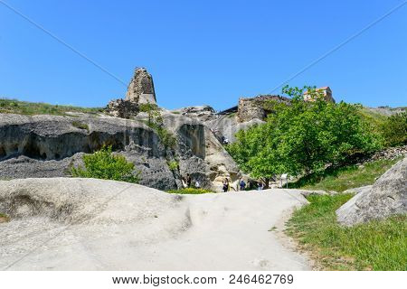 UPLISTSIKHE - MAY 5: Tourists enjoy the sunny weather and walk around the ancient rock city on 5 May 2018 in Uplistsikhe (Upliscyche), Georgia