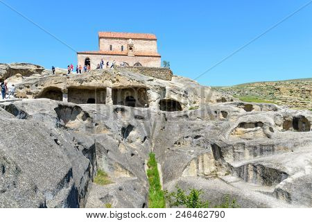 UPLISTSIKHE - MAY 5: Tourists enjoy the sunny weather and walk around the ancient rock city on 5 May 2018 in Uplistsikhe (Upliscyche), Georgia