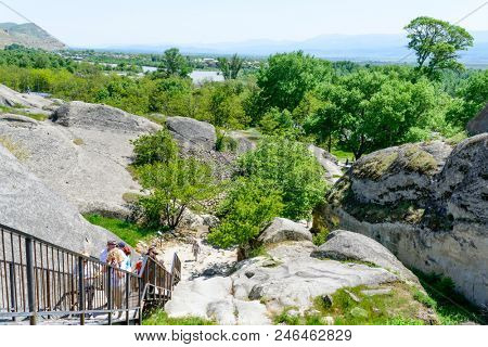 UPLISTSIKHE - MAY 5: Tourists enjoy the sunny weather and walk around the ancient rock city on 5 May 2018 in Uplistsikhe (Upliscyche), Georgia