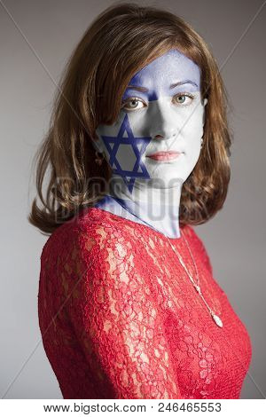 Portrait Of Woman With Painted Flag Of Israel On A Gray Background