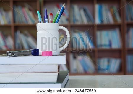 Pencil And Book On The Library Desk For Reading.