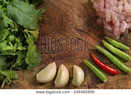 Raw Material Of Stir Fried Pork And Basil Such As Pork,basil,chilli,garlic On A Wooden Chopping Boar