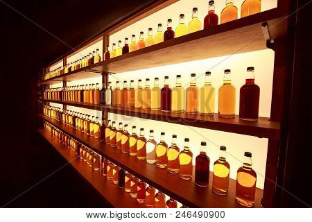 Whiskey Bottles In Rows On Display Shelf