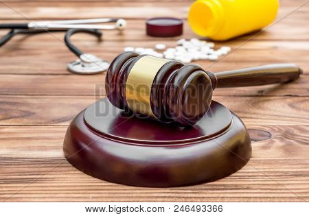 Gavel With Pills And Stethoscope On Wooden Background.