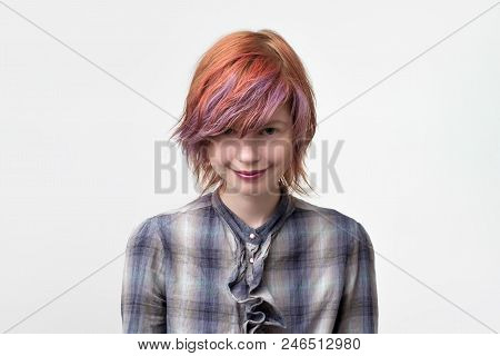 Pretty Woman Wtih Multi Colored Hairstyle Looking At Camera With Strange Smile And Ingratiating Expr