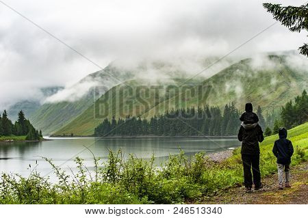 View Of A Beautlful Lake Talla In Scottish Borders With Green Hills Covered By Thick Rainy Clouds.
